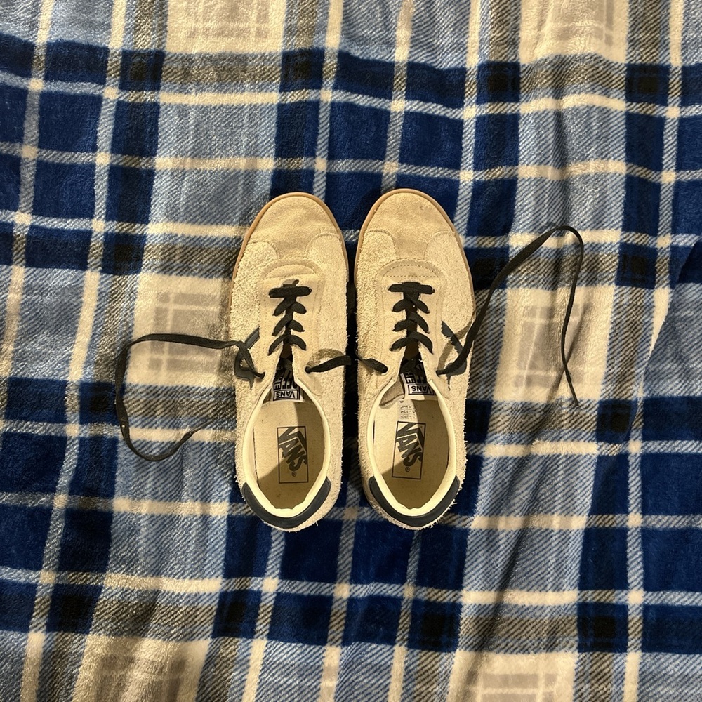 A pair of vans off white and navy suede sneakers